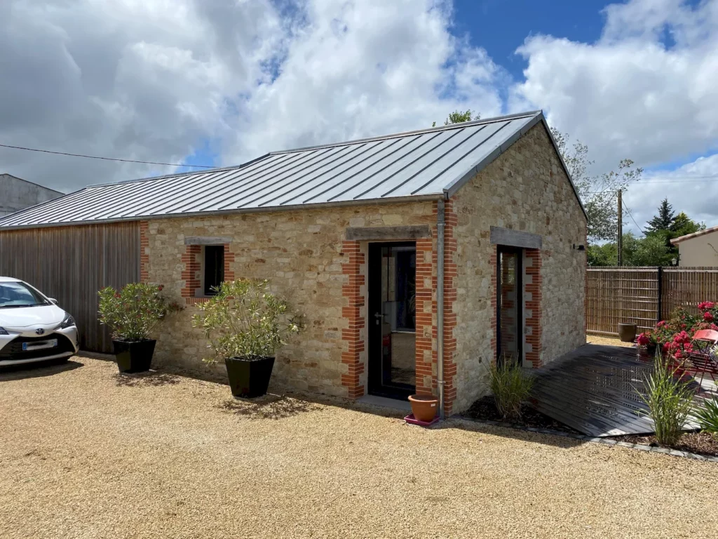 Grange rénovée avec pierres apparentes et briquettes et toiture en zinc