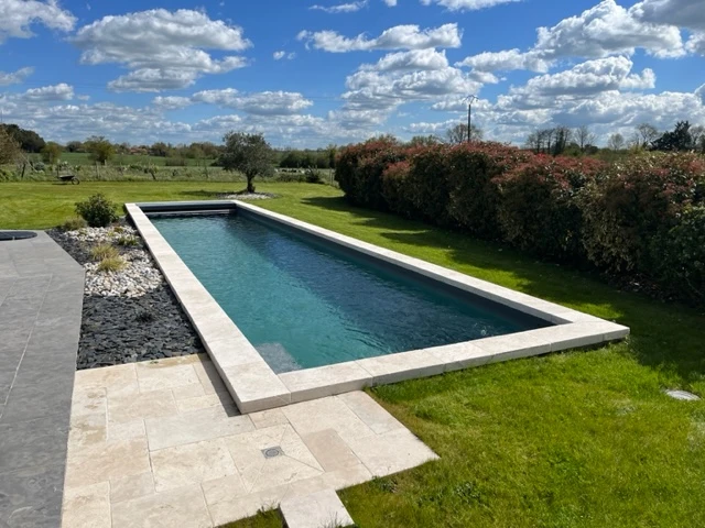 Piscine enterrée avec margelle en pierres